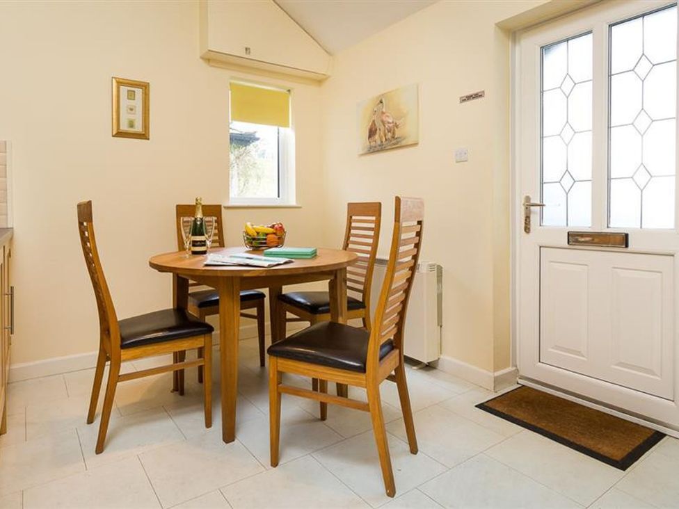 A dining room with a table and chairs at 2 Riverside Cottages Ambleside