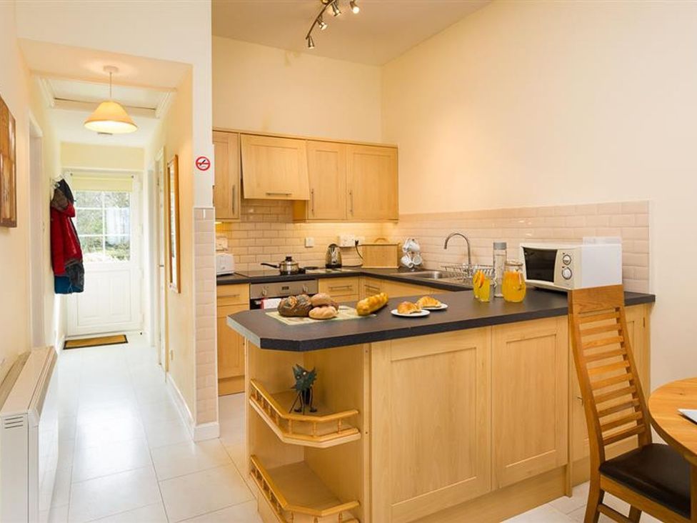 A kitchen with a countertop and dining table at 2 Riverside Cottages Ambleside