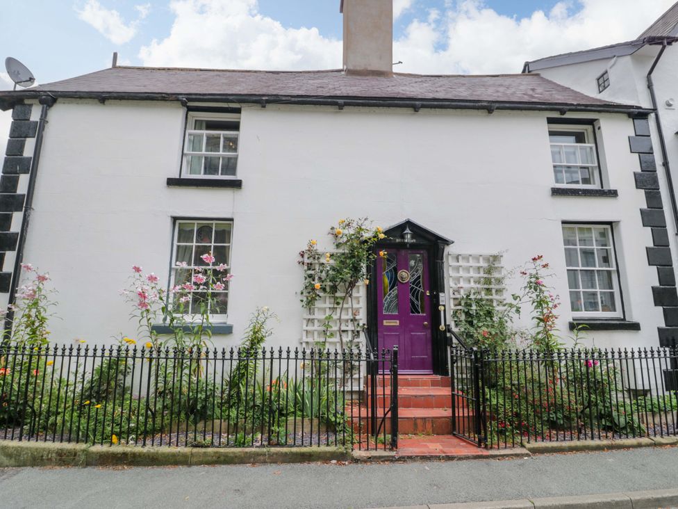 A house with a purple door and flowers in the garden at Bryn Dwr in Llangollen