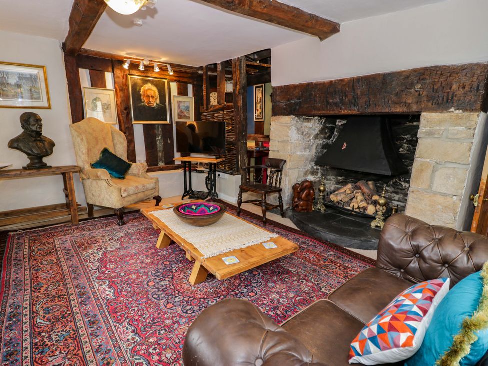 A living room with a fireplace and seating at Bryn Dwr in Llangollen