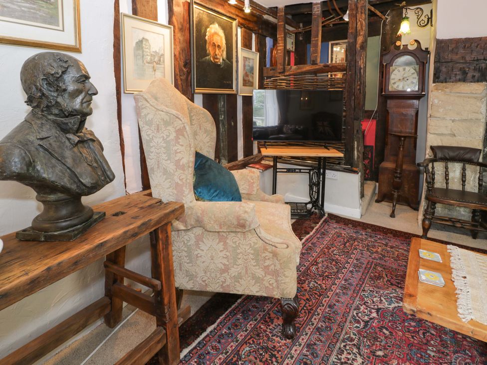 A living room with a television and a bust at Bryn Dwr in Llangollen