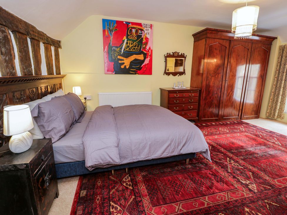 A bedroom with a bed and wardrobe at Bryn Dwr in Llangollen