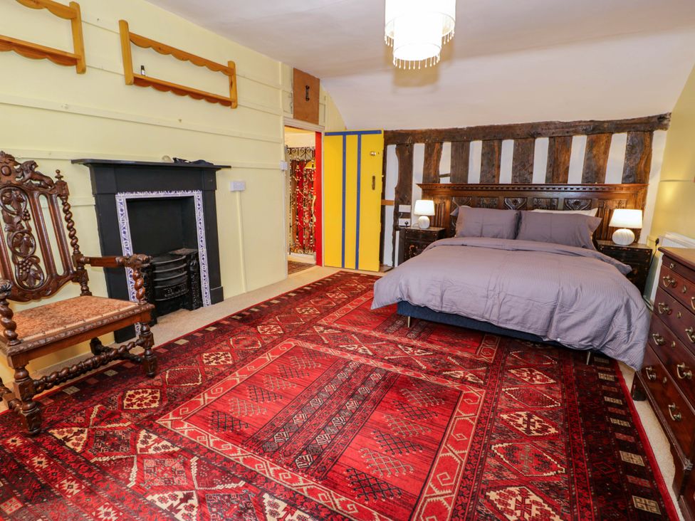 A bedroom with a bed and armchair at Bryn Dwr in Llangollen