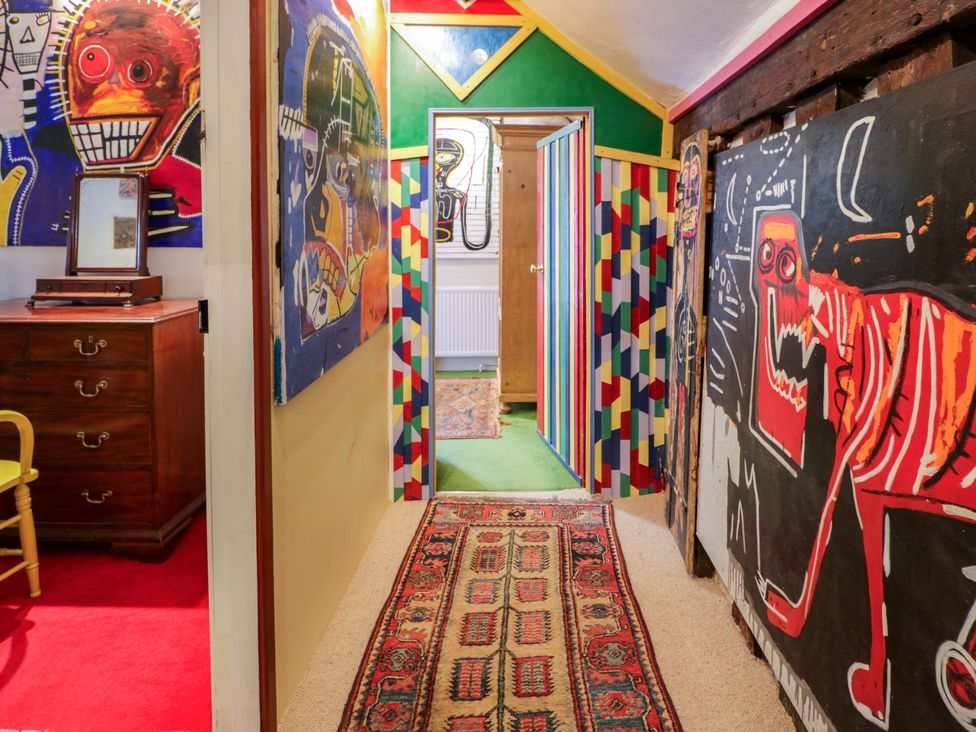A hallway with artwork and a chest of drawers at Bryn Dwr in Llangollen