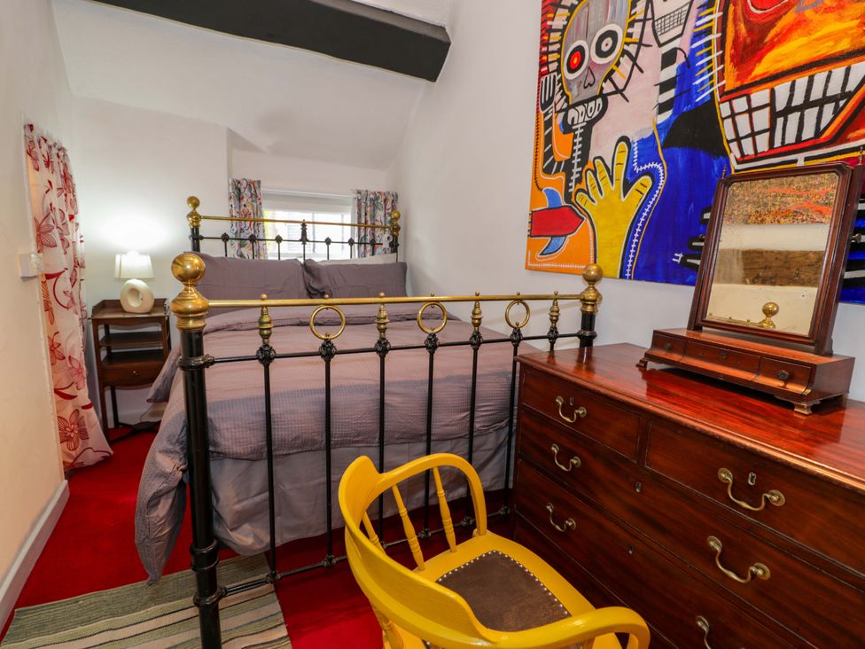 A bedroom with a bed, dresser and artwork at Bryn Dwr, Llangollen