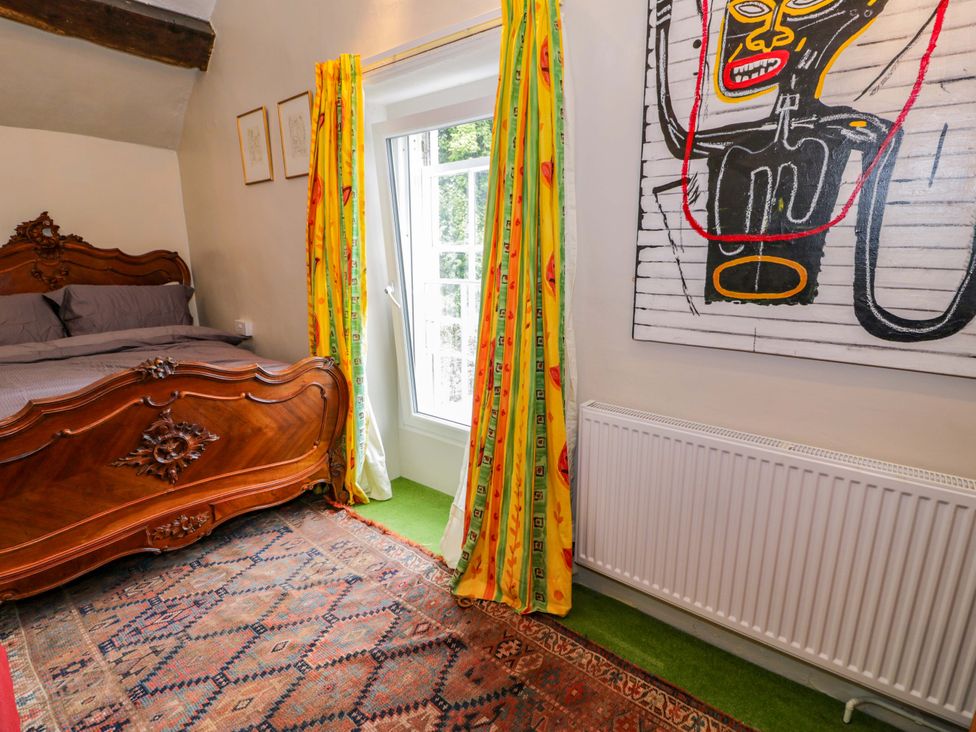A bedroom with a wooden bed and window in Bryn Dwr, Llangollen