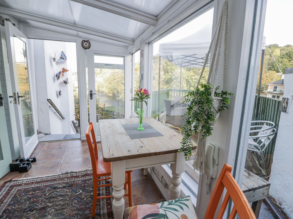 A conservatory with a table and chairs at Bryn Dwr in Llangollen