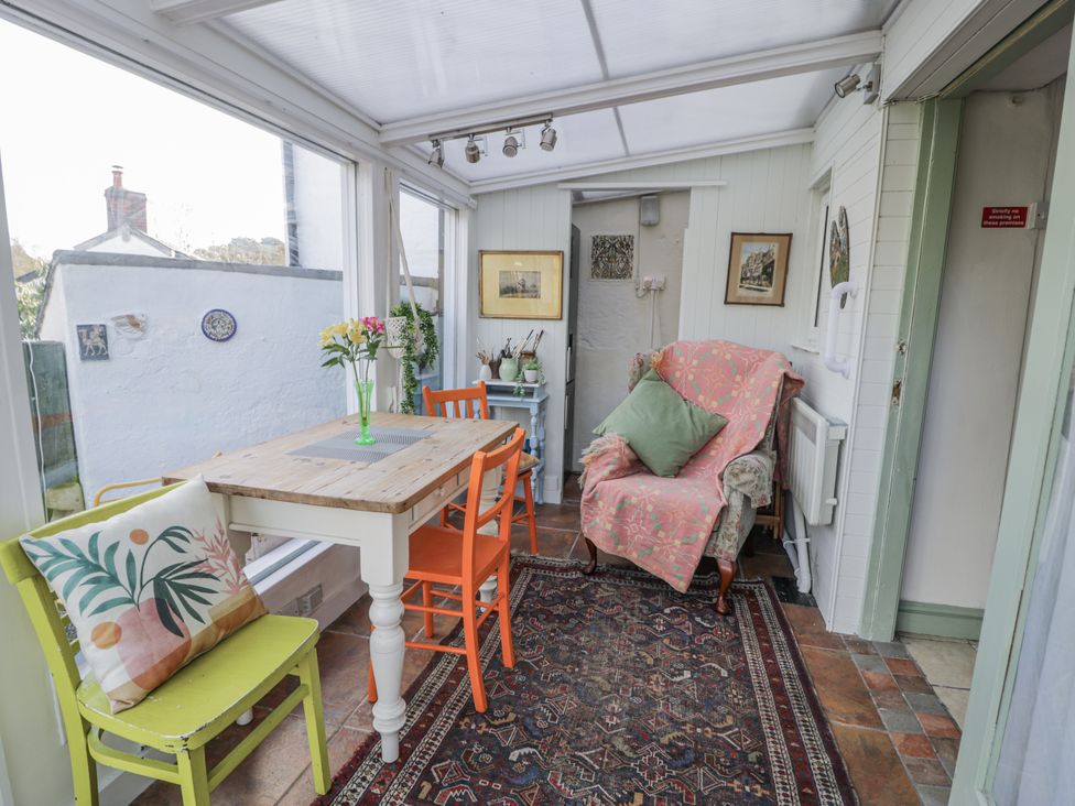A conservatory with a table and chairs at Bryn Dwr in Llangollen