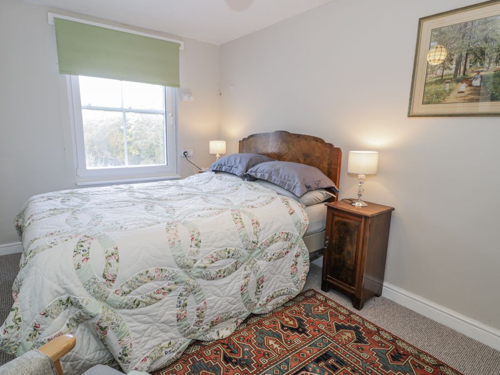 A bedroom with a bed and nightstand at Bryn Dwr in Llangollen