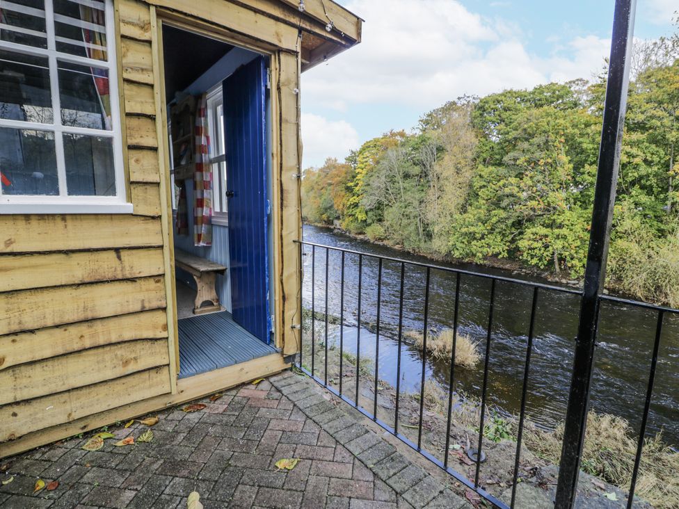 A wooden cabin with a view of a river at Bryn Dwr in Llangollen