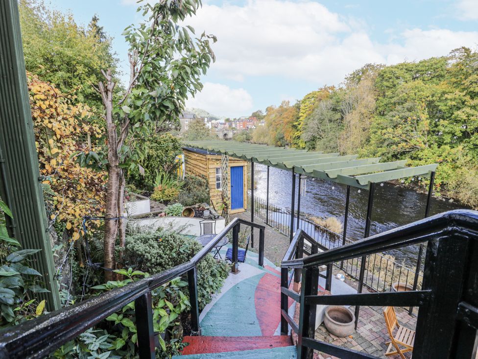 A garden with steps leading to a river at Bryn Dwr in Llangollen