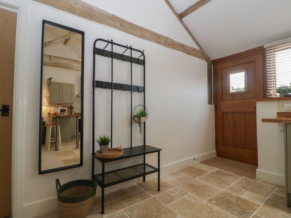 An entrance with a coat rack and mirror at The Old Cart Shed in Gorsley