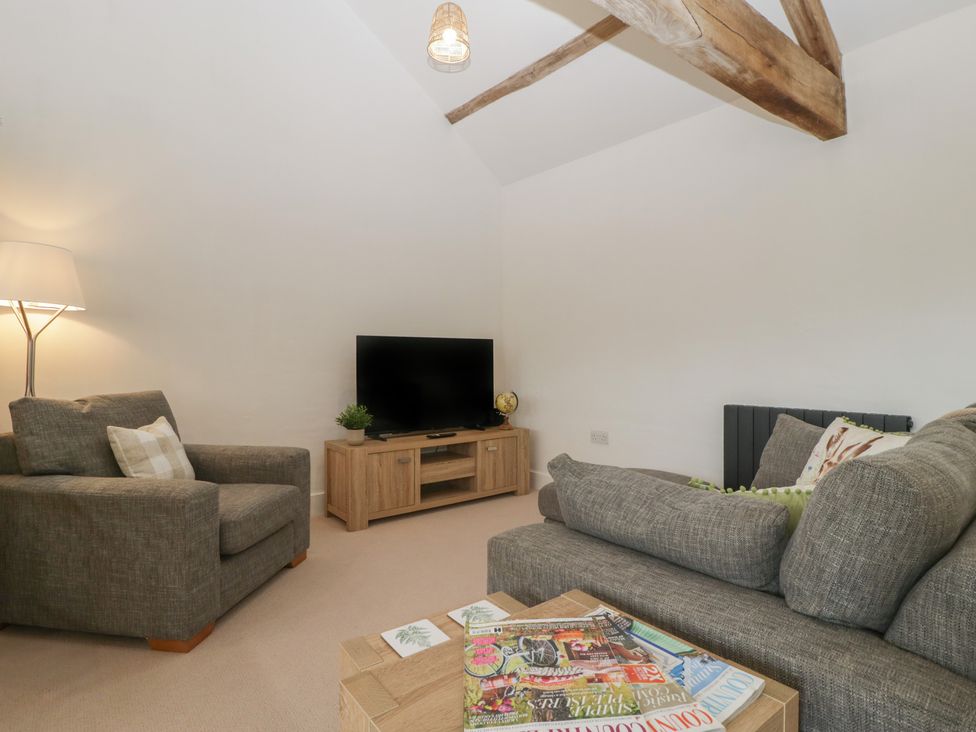 A living room with a television and seating area at The Old Cart Shed in Gorsley