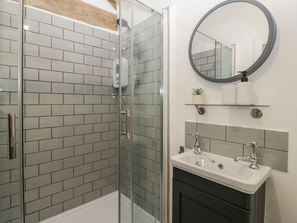 A bathroom with a shower and sink at The Old Cart Shed in Gorsley