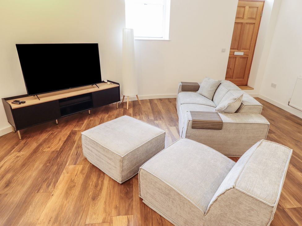 A living room with a sofa and television at 10c King Street in King's Lynn