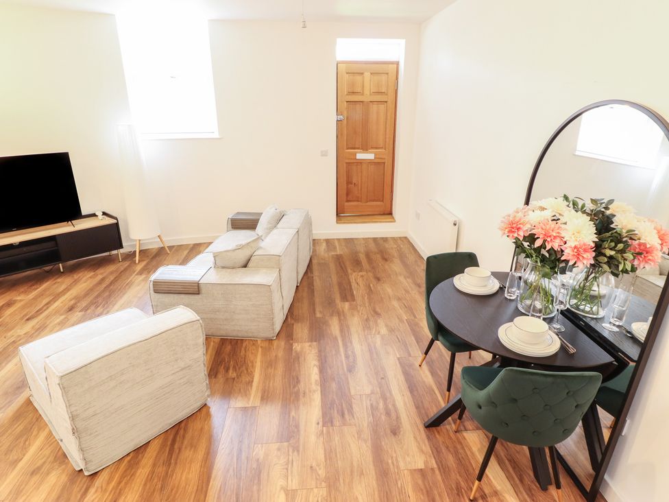A living room with a sofa and dining area at 10c King Street in King's Lynn