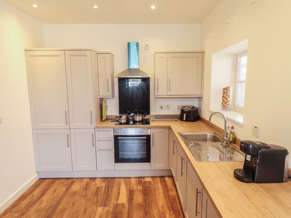 A kitchen with cabinets, a cooker, and a sink at 10c King Street, King's Lynn