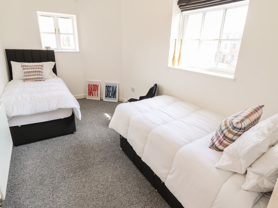 A bedroom with two beds and wall decor at 10c King Street in King's Lynn