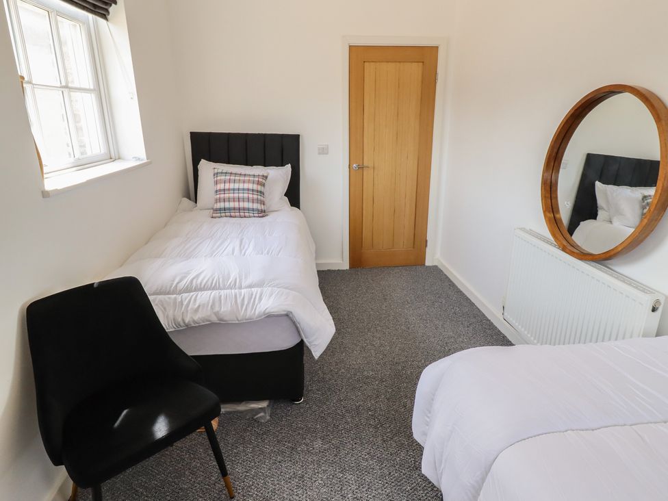 A bedroom with two beds and a mirror at 10c King Street in King's Lynn