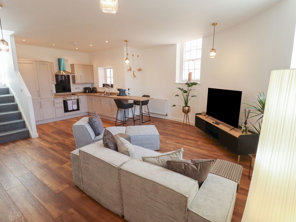 A living room with kitchen and dining area at Corner House in King's Lynn