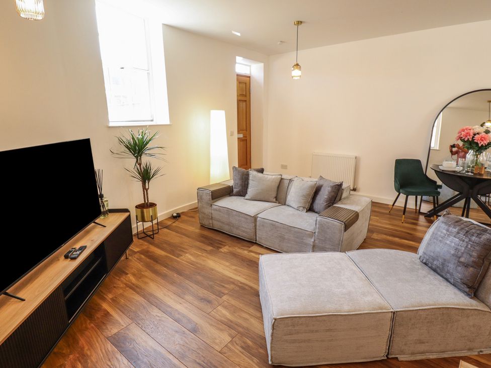 A living room with a television and sofa at Corner House in King's Lynn