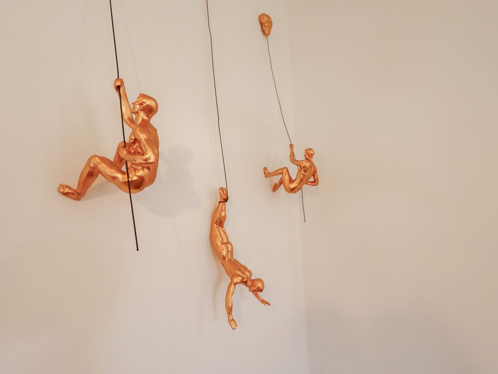 Hanging sculptures of climbers at Corner House in King's Lynn