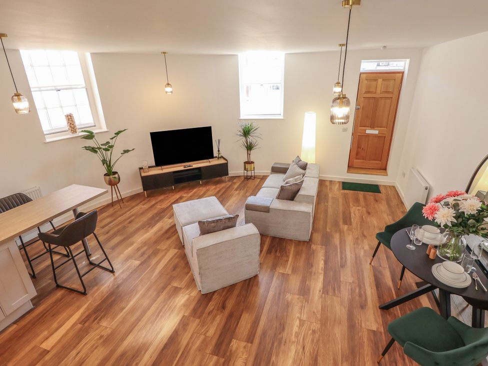 A living room with a sofa and dining area at Corner House in King's Lynn