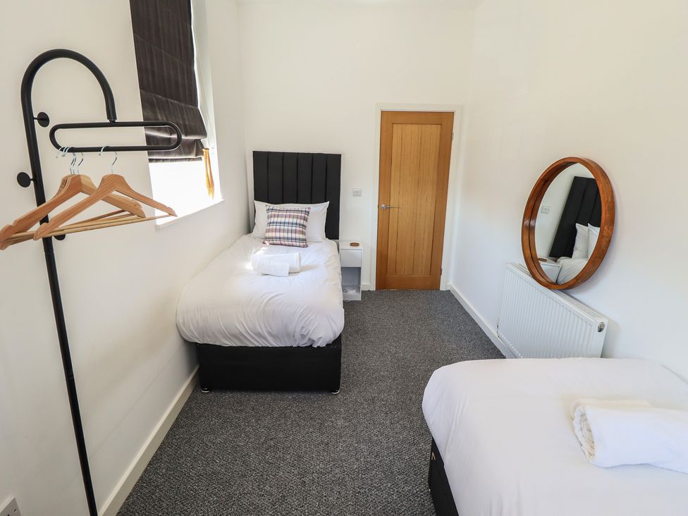 A bedroom with single and double beds at Corner House in King's Lynn