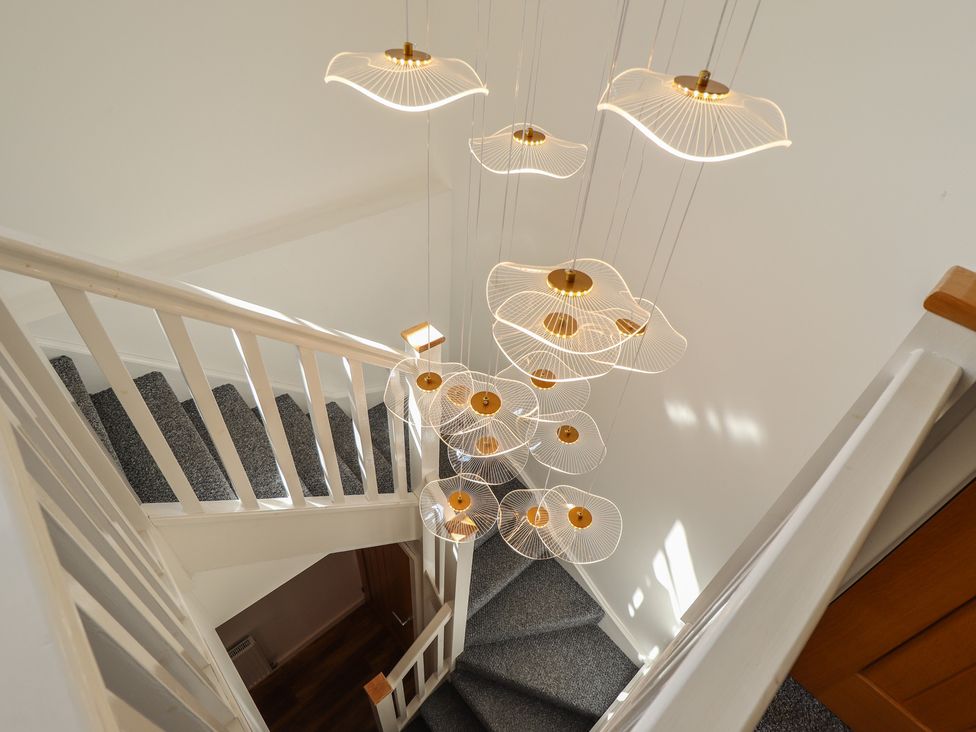 A stairway with a decorative light fixture at Corner House in King's Lynn