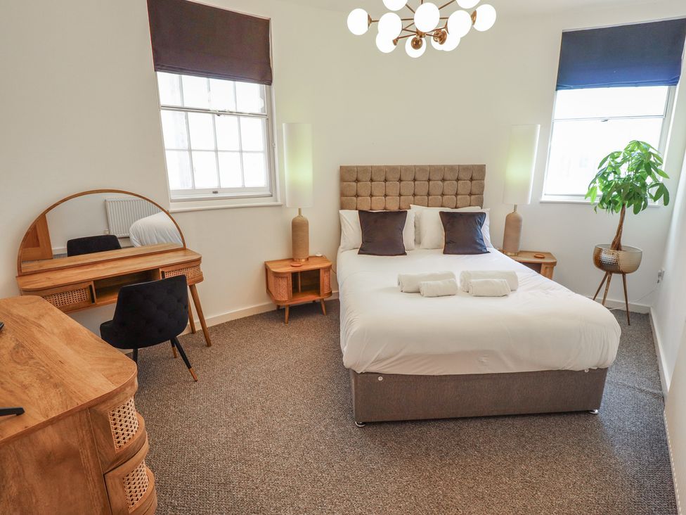 A bedroom with a bed and dressing table at Corner House in King's Lynn