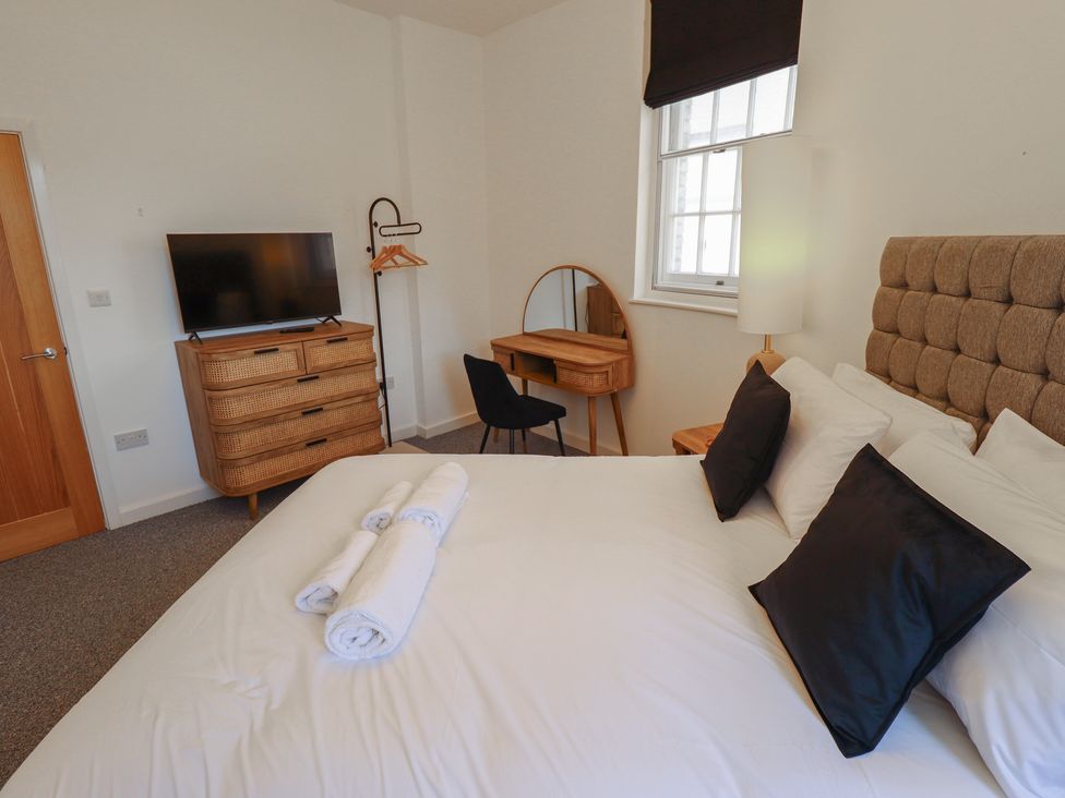 A bedroom with a bed and TV at Corner House in King's Lynn