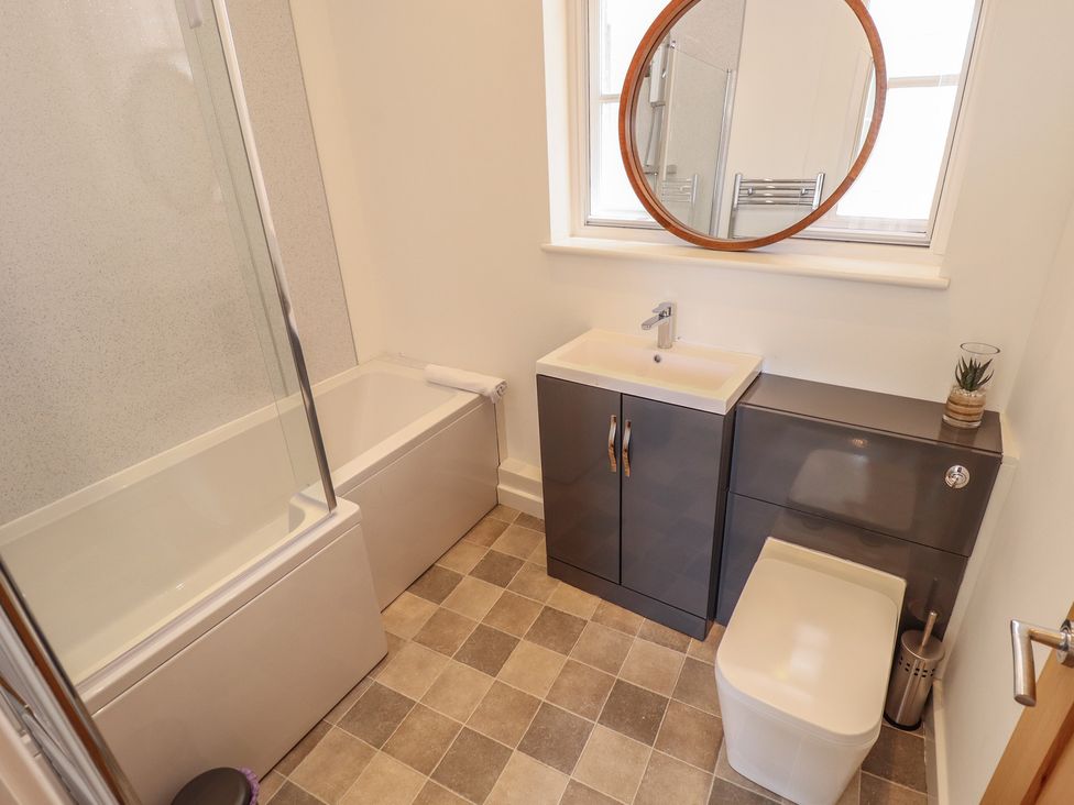 A bathroom with a bathtub, toilet, and sink at Corner House in King's Lynn