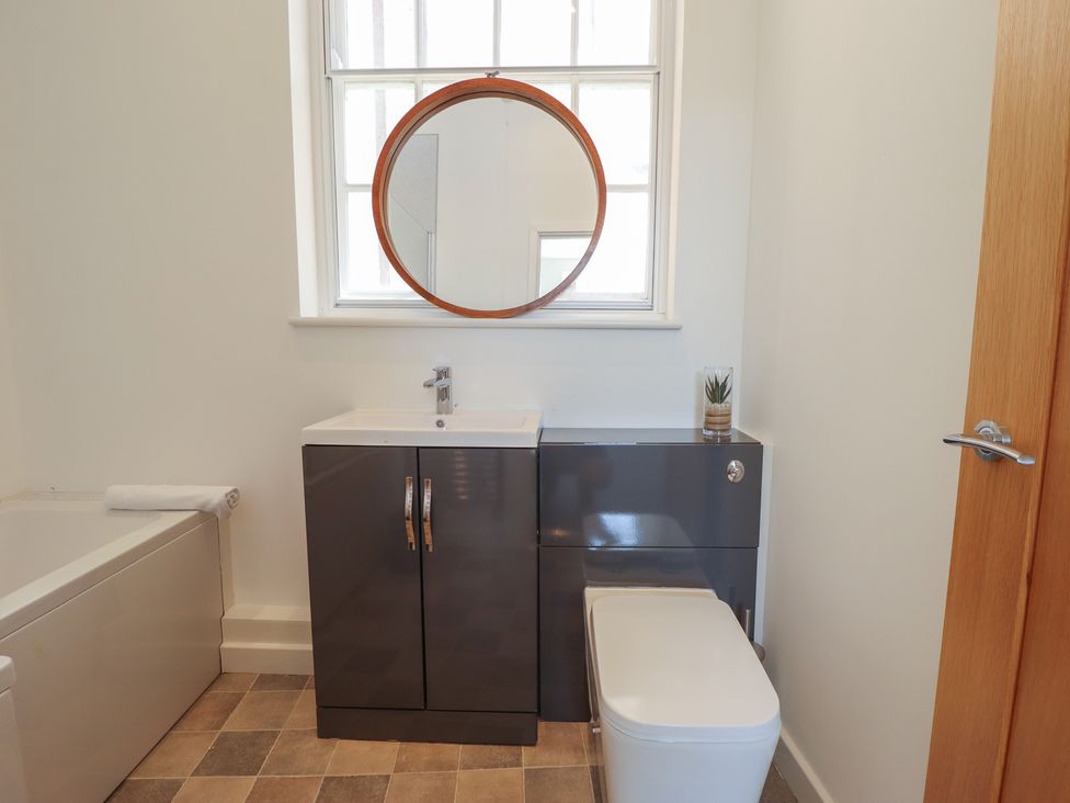 A bathroom with a sink, toilet, and bathtub at Corner House in King's Lynn