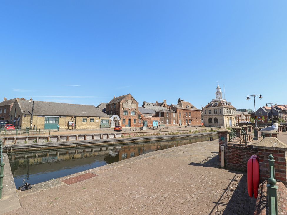 A canal with buildings and street features at Corner House in King's Lynn