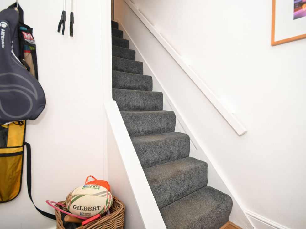 A staircase with carpet and a basket in the hallway at Seahorse in Filey