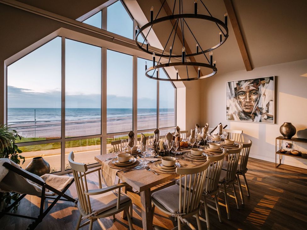 A dining room with a table set for a meal at Calm Waters Luxury Beach House in Bridlington