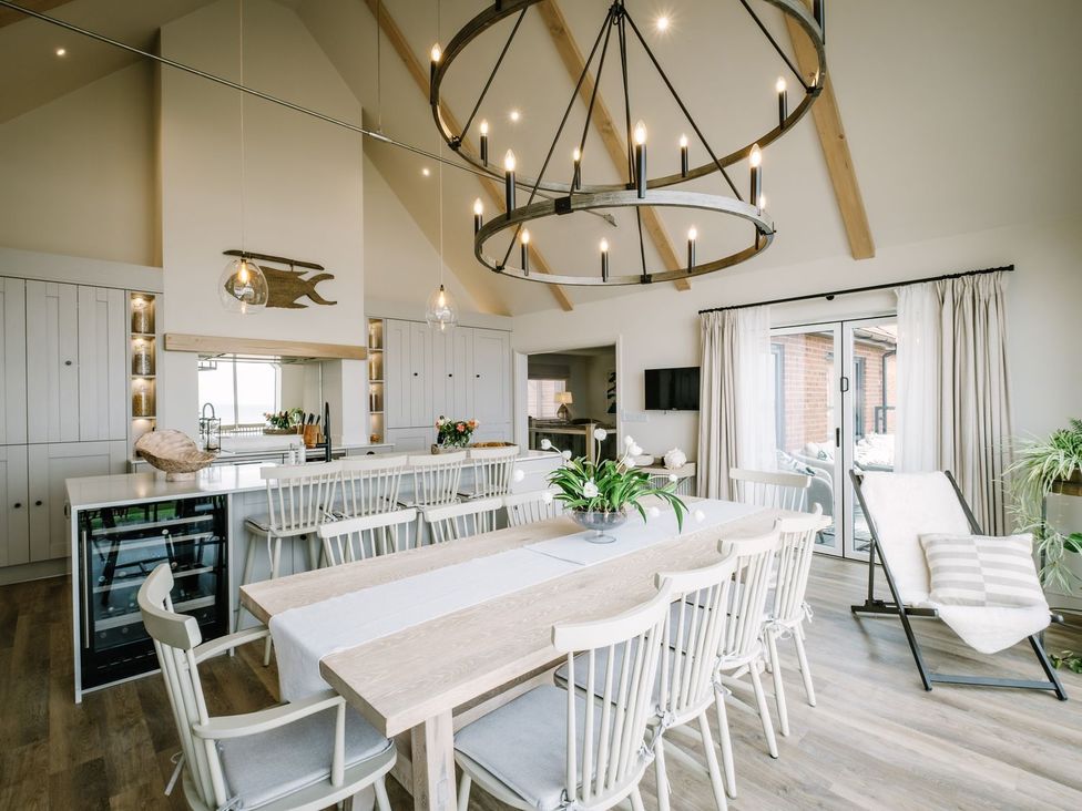 A kitchen with a dining table and chairs at Calm Waters Luxury Beach House in Bridlington