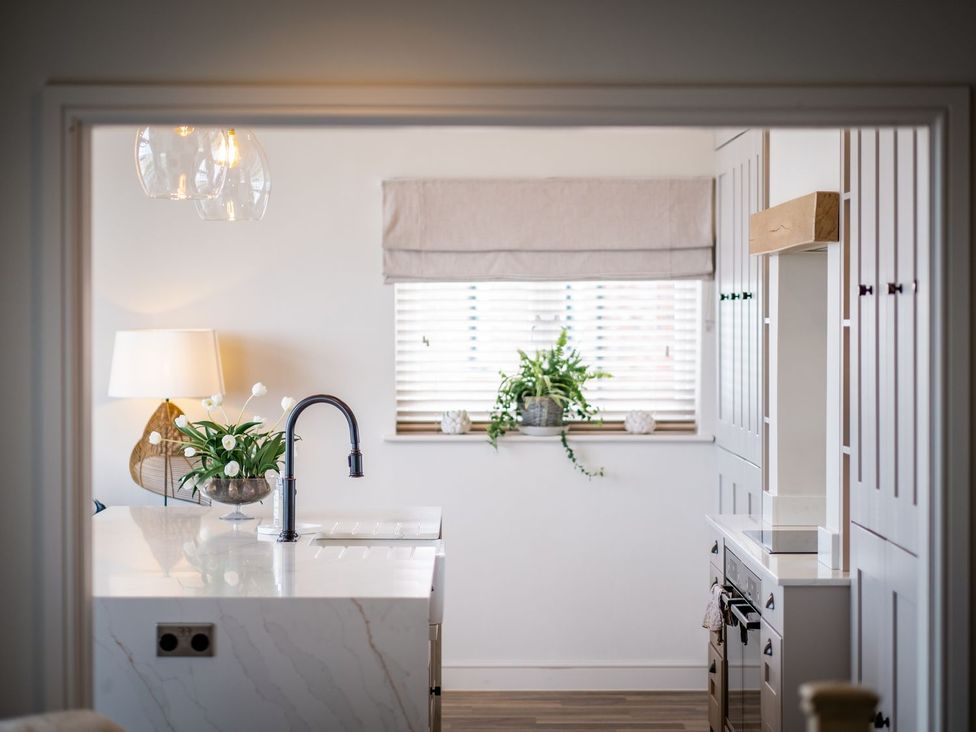 A kitchen with sink and cabinets at Calm Waters Luxury Beach House in Bridlington
