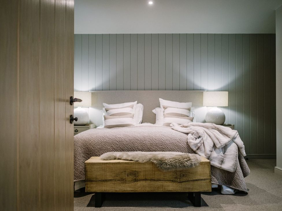 A bedroom with a bed and bedside tables at Calm Waters Luxury Beach House Bridlington