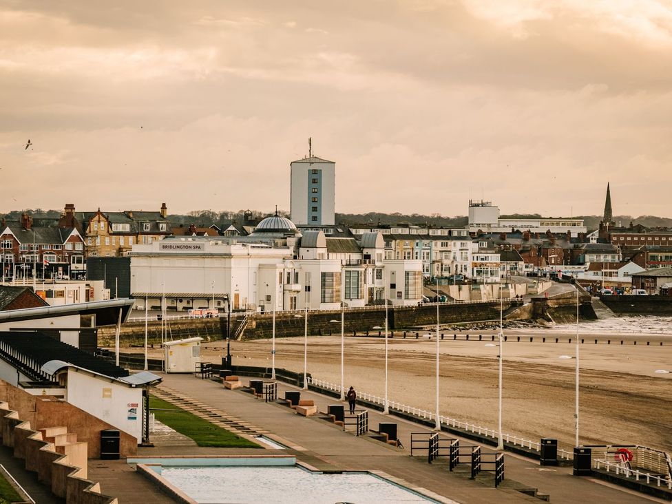 An outdoor view of beach and buildings at Calm Waters Luxury Beach House in Bridlington
