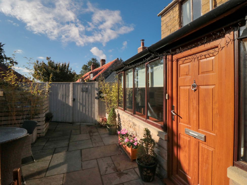 A garden with a wooden door and patio at 35 High Street, Scarborough