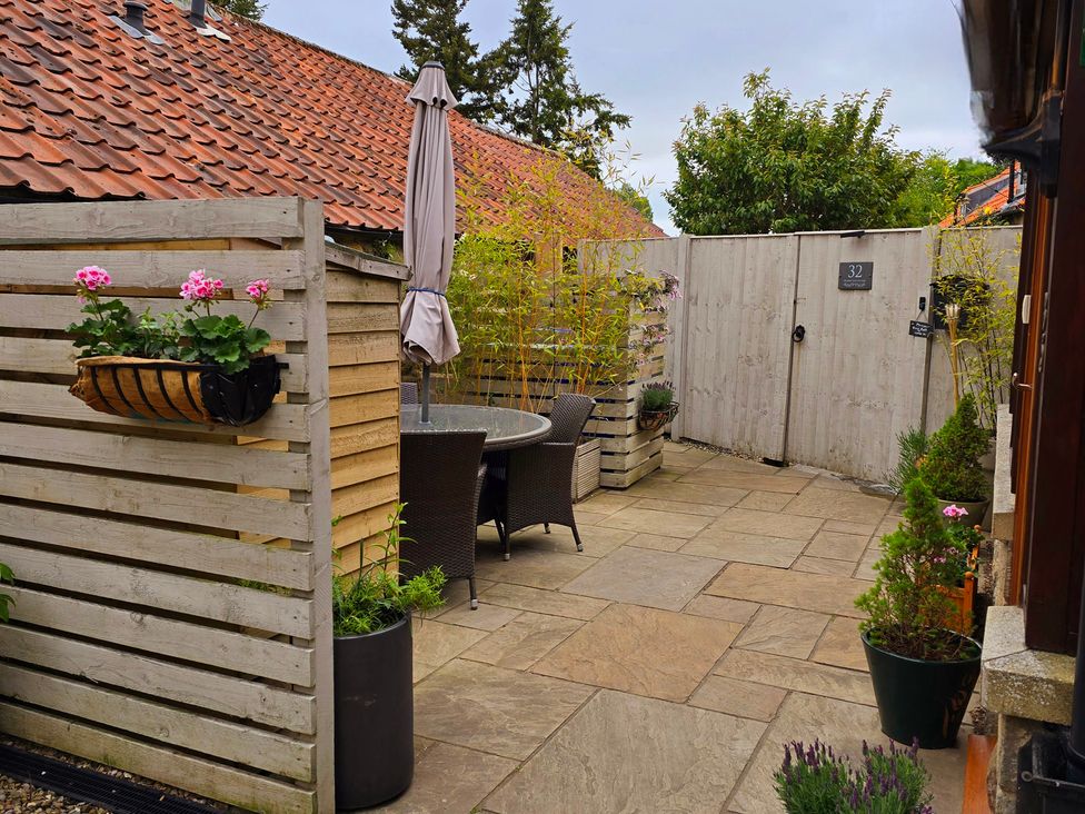 An outdoor area with a table and chairs at Minns Cottage Snainton