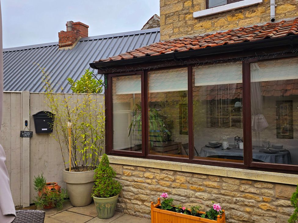 A garden with plants and a window view at Minns Cottage in Snainton