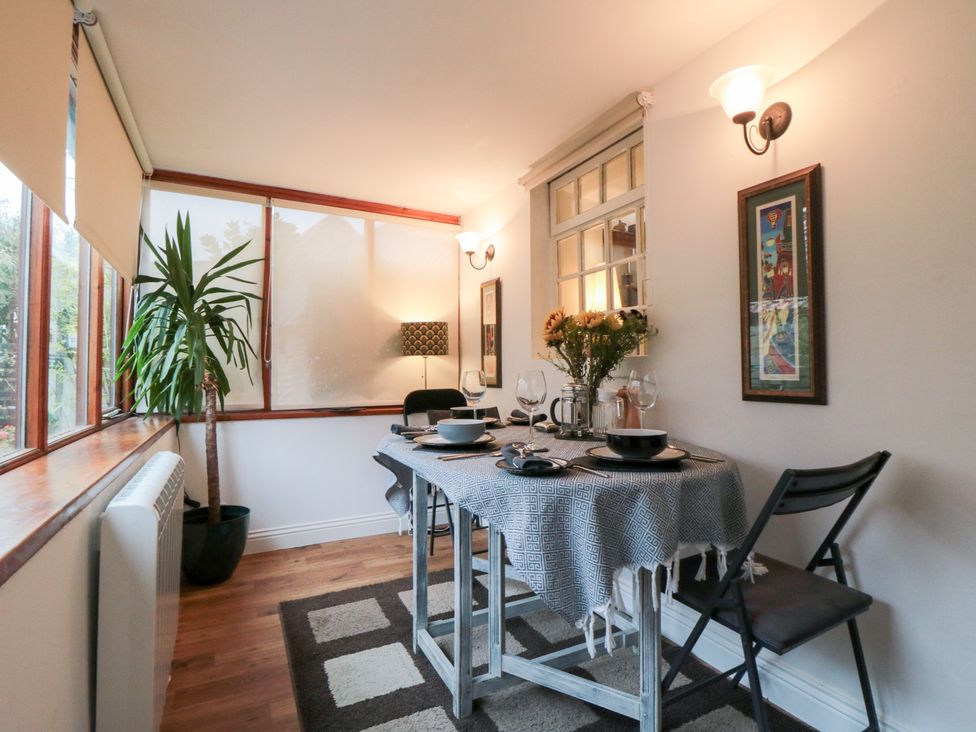 A dining room with a table set for meals at Minn's Cottage in Snainton