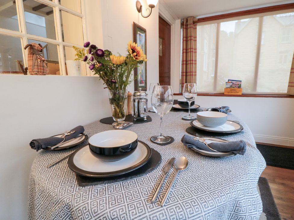 A dining room with a set table and flower arrangement at Minn's Cottage Snainton
