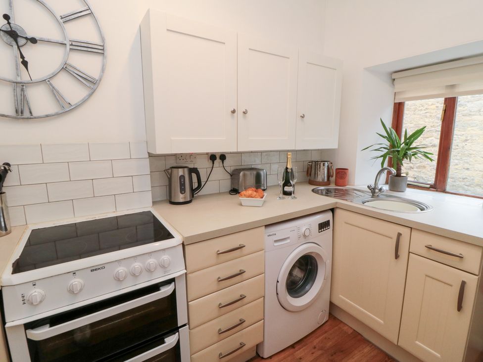 A kitchen with appliances and cabinets at Minn's Cottage Snainton
