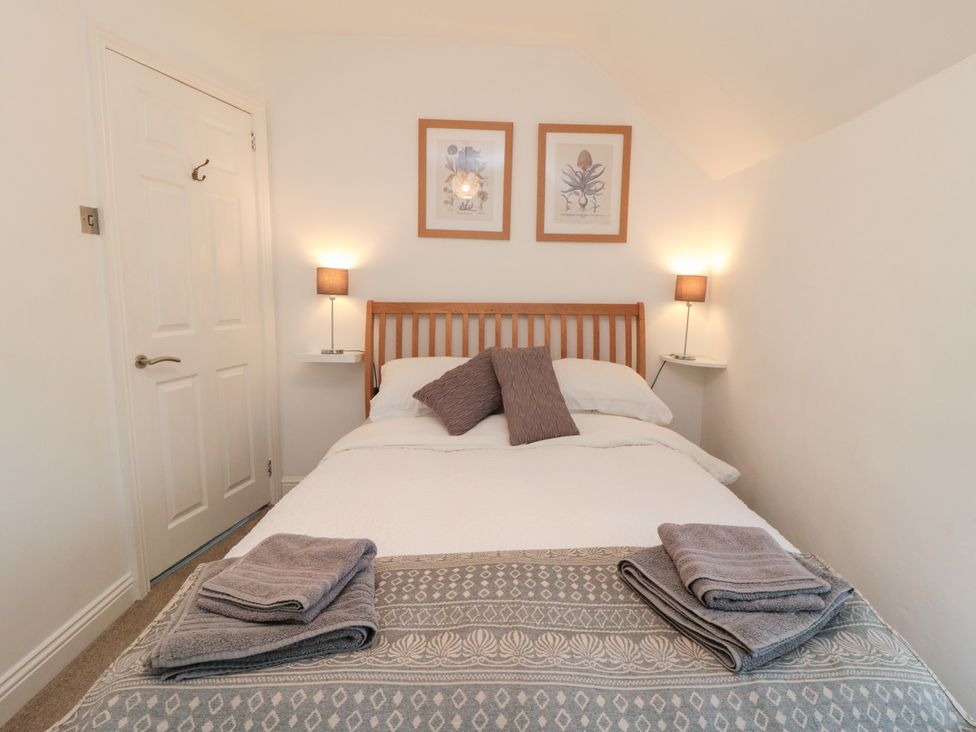 A bedroom with a bed and wall decor at Minn's Cottage in Snainton