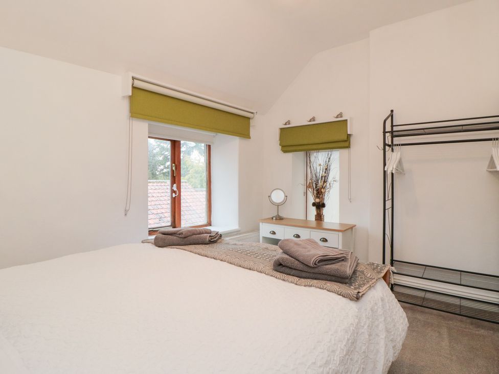 A bedroom with a bed and window at Minn's Cottage Snainton