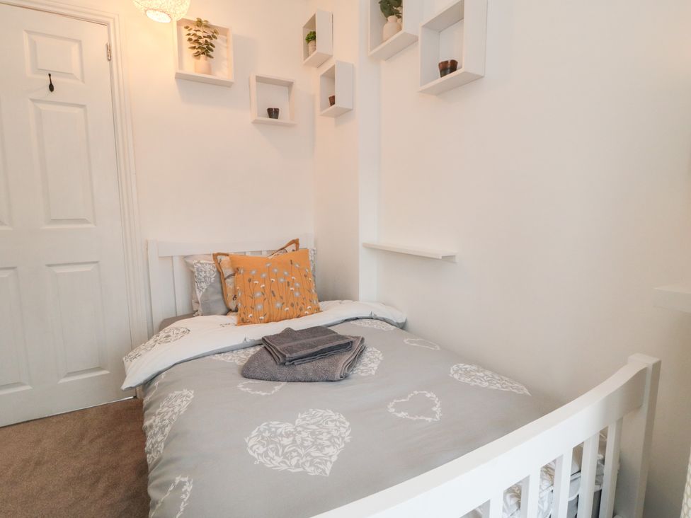 A bedroom with a bed and shelves at Minn's Cottage in Snainton