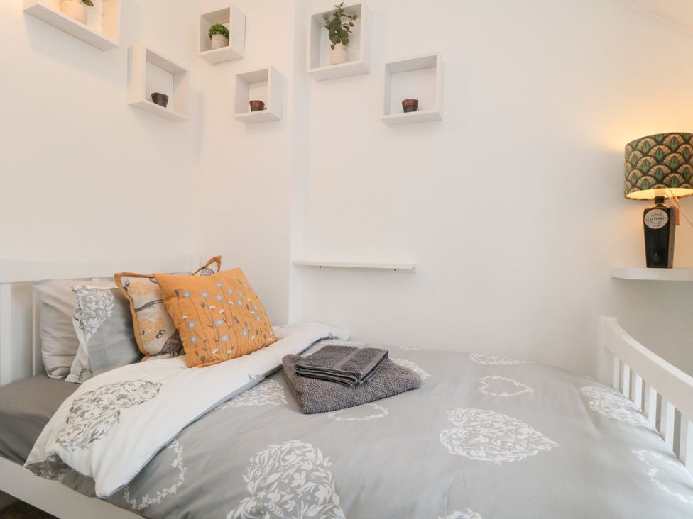 A bedroom with a bed and decorative items at Minn's Cottage in Snainton